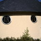 Die rechte Kirchenseite verfügt über zwei Fenster. Neben dem Regenablauf...